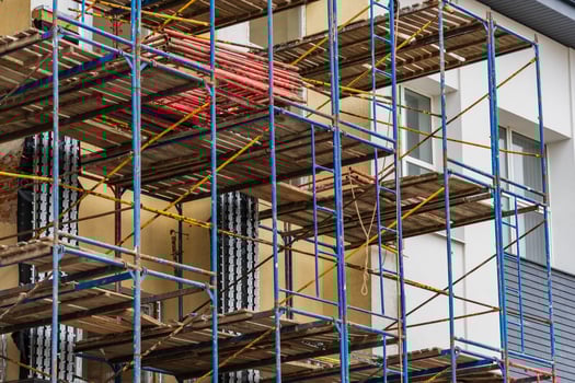 Workers prepare scaffolding around a building for renovation tasks while ensuring safety and accessibility for construction efforts photo