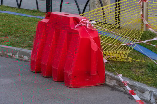 Construction barriers and caution tape are set up around a work site in the city, alerting pedestrians to stay clear of the area photo