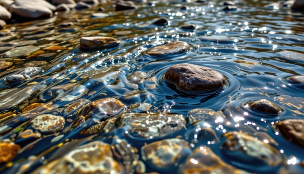 a crystal clear alpine stream with underwater stones visible. photo