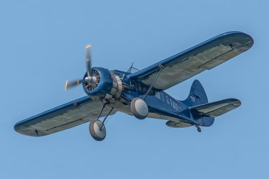 Vintage blue airplane flying in clear sky photo