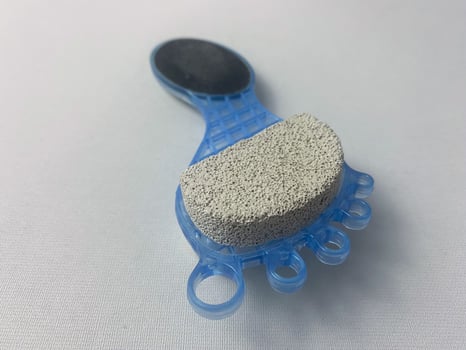 Blue foot scrubber with pumice stone and rasp, ideal for foot care and pedicure photo