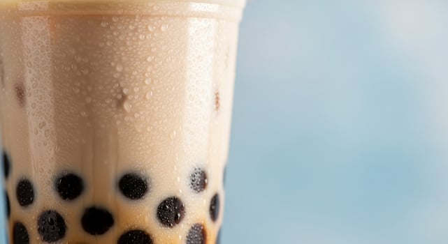Refreshing Bubble Tea with Tapioca Pearls and Condensation on Plastic Cup photo