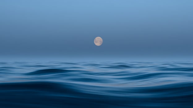 Serene Ocean Waves Under a Full Moon in a Tranquil Night Sky photo