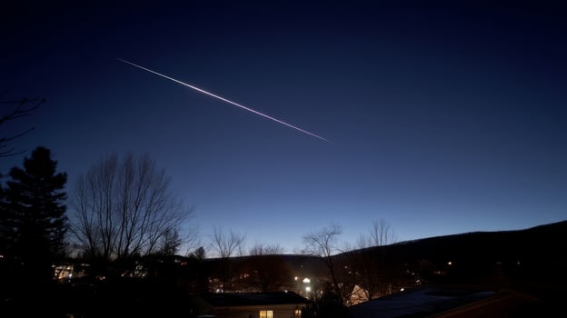 Stunning Meteor Shower with Bright Trail Illuminating Night Sky Over Serene Landscape and Suburban Homes photo