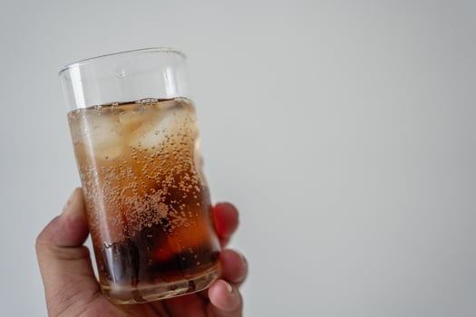 A transparent glass of iced cocktail drink rum or whiskey with visible ice cubes and soda photo