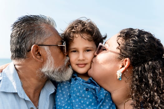 Happy parents kissing grandson on the cheek, family love photo