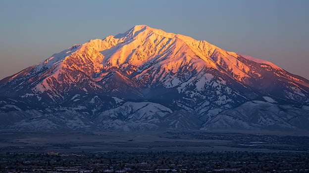 Majestic Sunset over a Snow-Capped Mountain Range. A breathtaking view of a dramatic alpine landscape at golden hour. photo