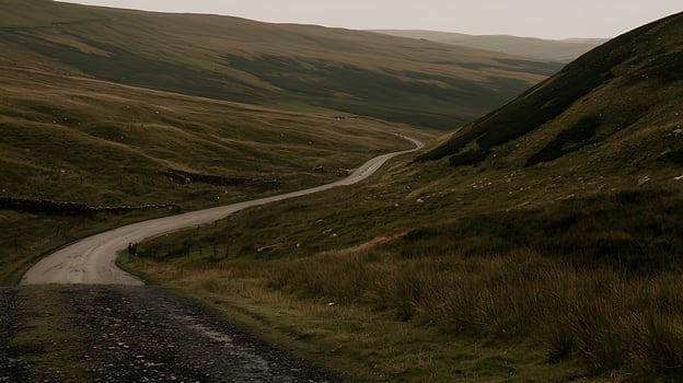 Winding Road Through Rolling Green Hills and Mountains. A scenic view of a countryside road curving through a serene landscape. photo