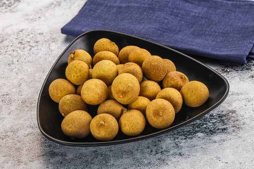 A black bowl filled with small yellow fruit photo