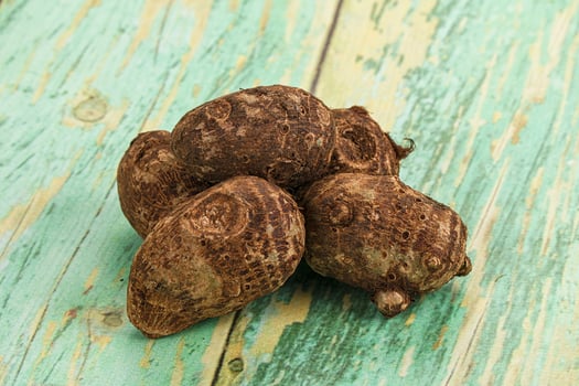 A pile of raw coconuts on a wooden table photo