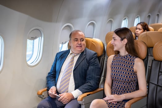 Caucasian businessman travels in formal wear and his partner sitting comfortably in the aircraft photo