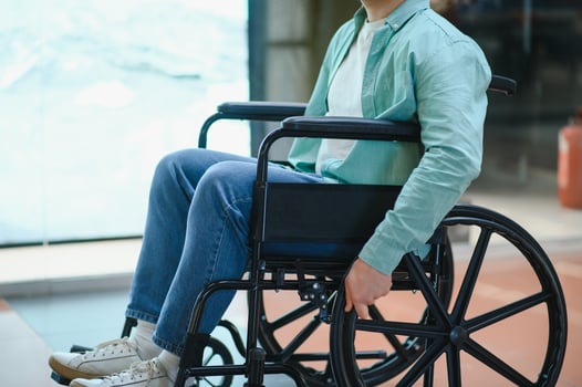 Young man moving in wheelchair through shopping center corridor photo