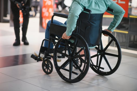 Customer in wheelchair moving through shopping center corridor photo
