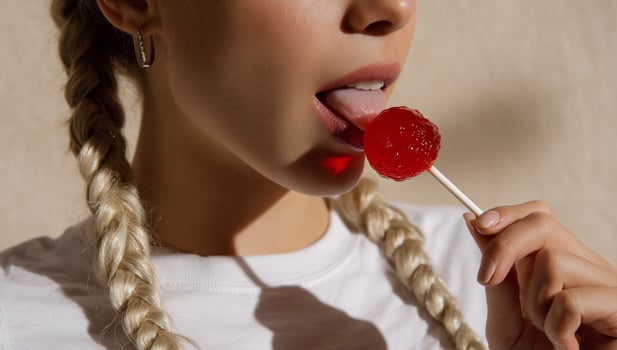 A woman with braids eating a lollipop photo