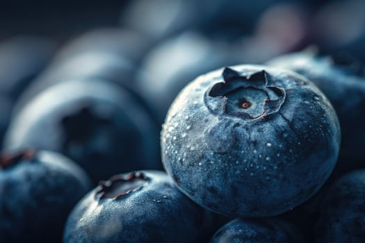 A close up shot showcases the vibrant blueberries, their textures, and water droplets. photo