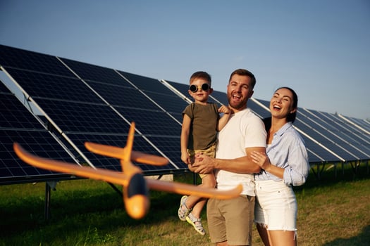 Family is together. Father, mother ,and, little son are outdoors near solar panels photo