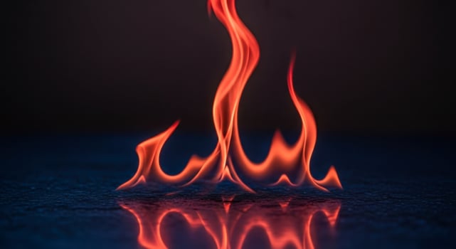 Vibrant Red and Orange Flames Reflecting on a Dark Surface with Intense Glow photo