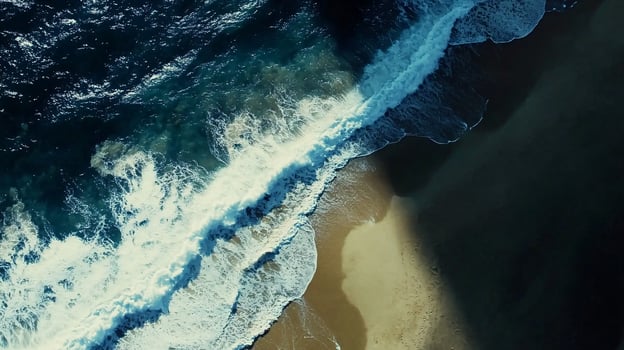 Aerial View of Turquoise Ocean Waves Gently Crashing Against Golden Sandy Shoreline photo