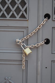 Chain lock securing an old wooden door with a padlock photo