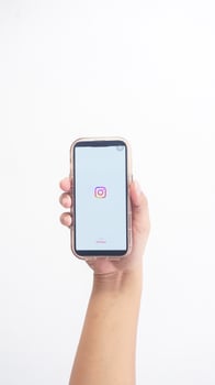 Yogyakarta, Indonesia, 2025 - Hand holdingHand holding smartphone that shows front page of Instagram platform application on screen isolated on white background photo