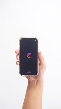 Yogyakarta, Indonesia, 2025 - Hand holdingHand holding smartphone that shows opening page of Instagram platform application on screen isolated on white background photo