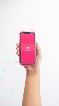 Yogyakarta, Indonesia, 2025 - Hand holdingHand holding smartphone that shows Lazada application icon, e-commerce platform from Indonesia, on screen isolated on white background photo