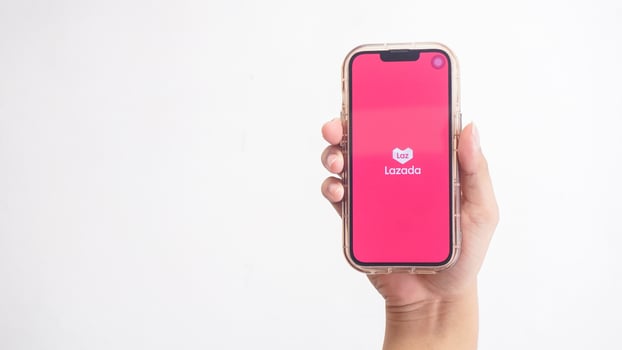 Yogyakarta, Indonesia, 2025 - Hand holdingHand holding smartphone that shows Lazada application logo, e-commerce platform from Indonesia, on screen isolated on white background photo
