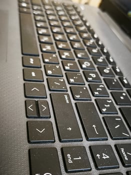 A black keyboard with a few keys missing. The keys that are missing are the enter key and the shift key photo
