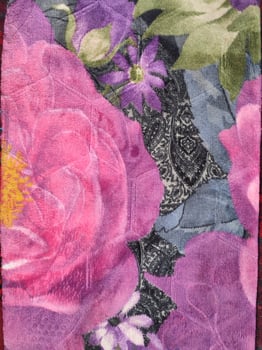 a purple and pink floral quilt with a flower on it photo
