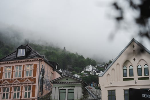 Bergen, Norway - July 10, 2024. historic architecture, mural, hillside homes in heavy fog, rainy day photo