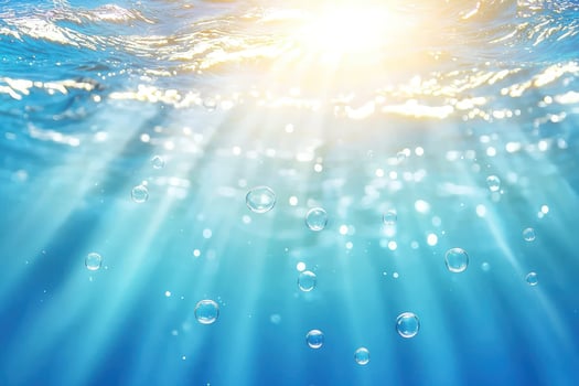 Bubbles floating to sunbeams under ocean surface, background for nature or travel photo