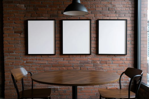 Empty frames on brick wall above cafe table by window photo