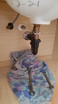 Doing Plumbing Work Under the Bathroom Sink, Wrenches on a Towel photo
