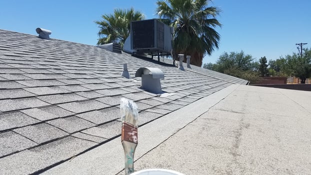 Holding a Paintbrush, Painting Roof Flashing on an Old House photo