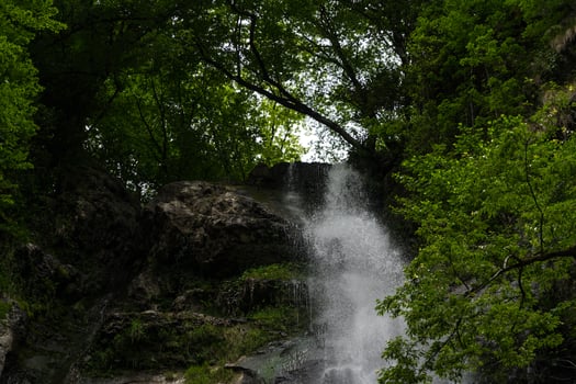 A small waterfall in the forest in the mountains of Georgia photo
