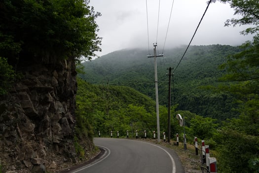 Turn of the road with incredible view of mountains and forest in fog, cloudy photo