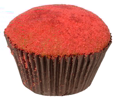 A single red velvet cupcake with red crumbs on top, baked in a dark brown paper liner, isolated background photo