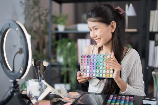 a woman is holding a makeup palette. photo