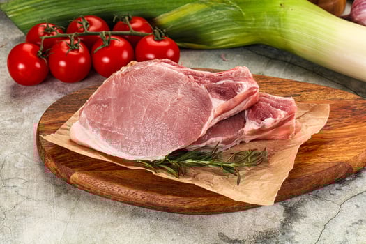A cutting board with meat, vegetables and tomatoes photo