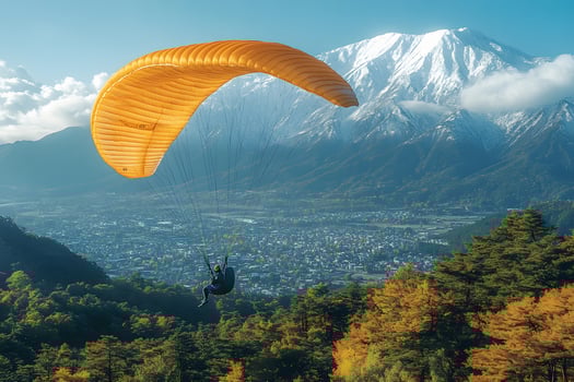 Autumn Paragliding Adventure Over Mountain Landscape and Snow-Capped Peaks photo