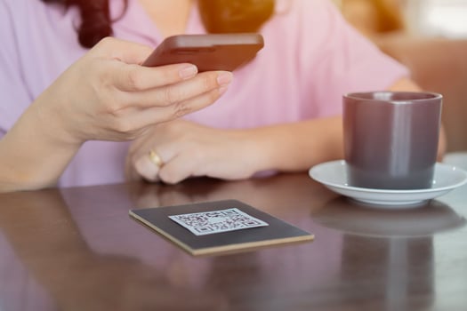 Woman customer handing smartphone make a quick and easy contactless payment in restaurant. photo