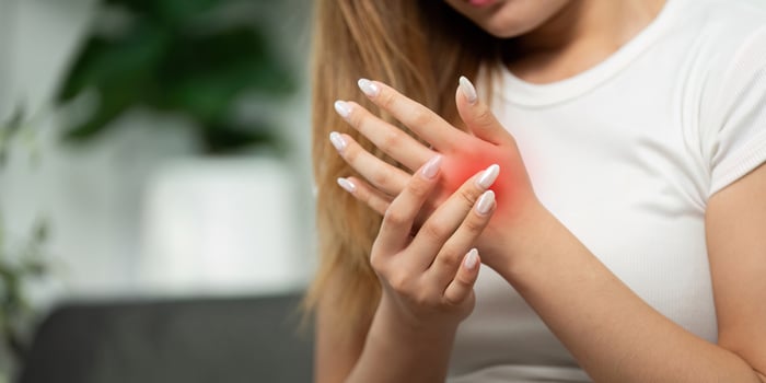Wrist Discomfort. Young woman experiencing pain while holding her wrist. photo