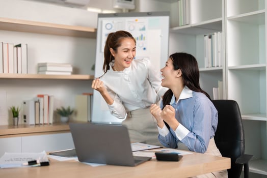 Team Celebration and Collaboration. Two young women celebrating a successful project in a modern office. photo