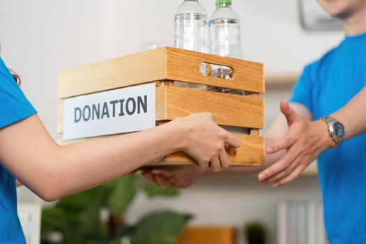 Donation Contribution. Volunteers handing over a wooden crate filled with donations at a community center. photo