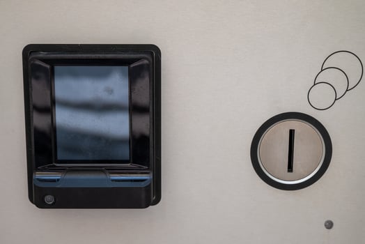 Electronic payment device on a metallic surface, featuring a rectangular black card reader with a screen. photo