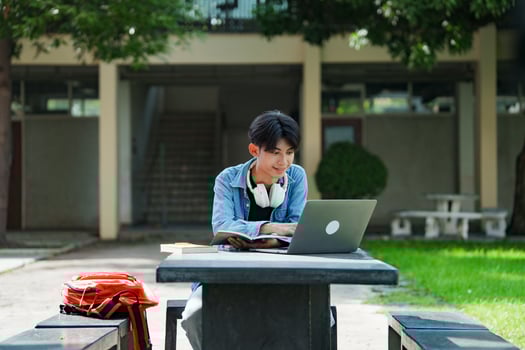 University student studying on campus outdoor with laptop casual lifestyle. photo