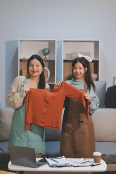 Two women holding up a shirt photo