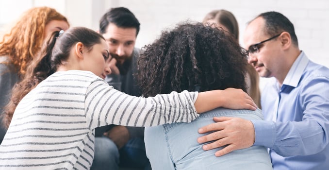 Support group meeting. Addicted people comforting upset woman at therapy session, free space photo