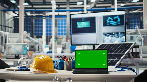 Green screen laptop in factory used to monitor performance of robot arms manufacturing solar panels. Chroma key notebook in empty industrial facility used to inspect photovoltaics machines photo