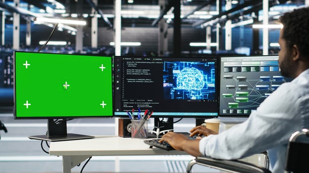 Engineer with paraplegia using AI deep learning algorithms on green screen PC to analyze datasets. Server room worker in wheelchair at chroma key PC using AI neural networks, camera B photo
